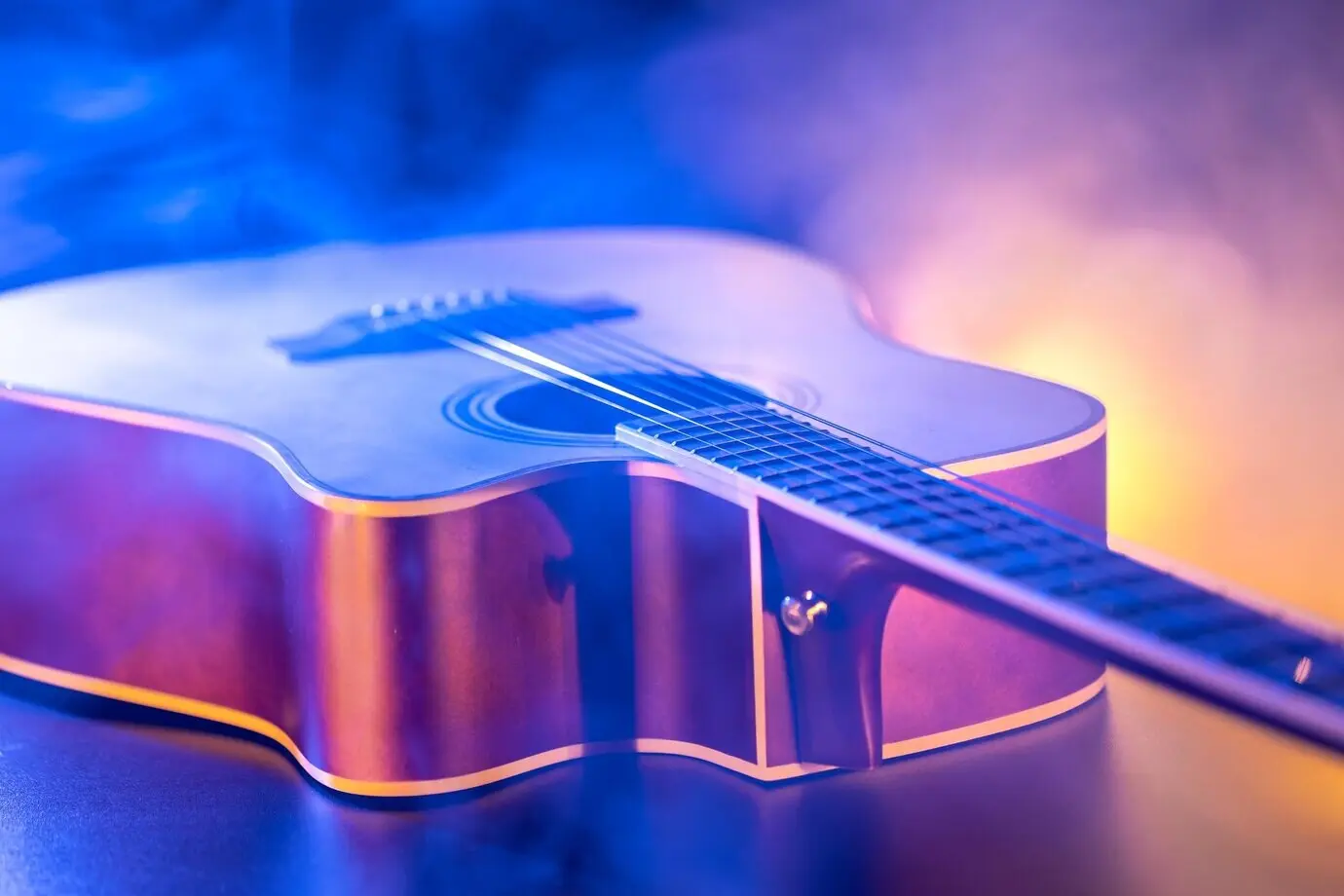 Nahaufnahme von Gitarre und Saiten mit geringer Schärfentiefe und weichem Fokus.